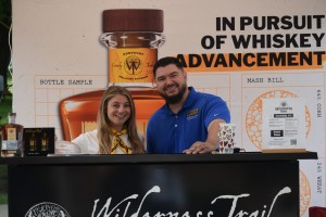 Haley Perros and Noah Baker greet attendees while working the Wilderness Trail Distillery booth during the Great American Brass Band Festival in Danville on Saturday, May 31, 2025. (Photo by Casey Roberts)