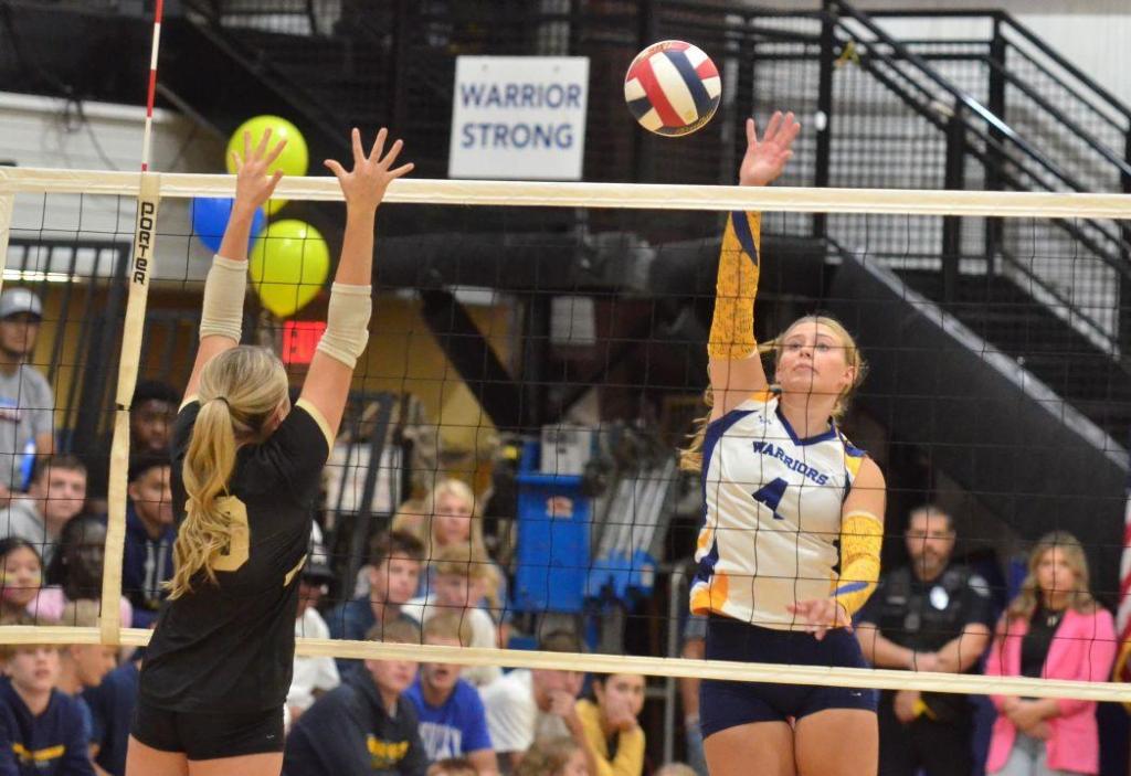 Grace Meyer, right, of Danville Christian spikes the ball toward Boyle County blocker Caroline Adams during the first set Tuesday. (Photo by Mike Marsee)