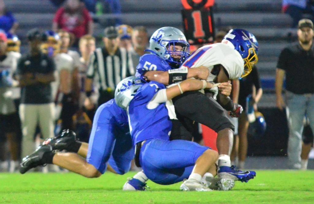 David Shelton, left, and Mylan Peters of Danville take down Washington County’s Elyjah Keene during the second quarter Friday. (Photo by Mike Marsee)